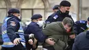 Polisi antihuru-hara menahan seorang pengunjuk rasa terkait pembatasan COVID-19 di Bucharest, Rumania, Senin (29/3/2021). Ribuan pengunjuk rasa antipembatasan turun ke jalan sehari setelah langkah pembatasan baru diberlakukan. (AP Photo/Vadim Ghirda)