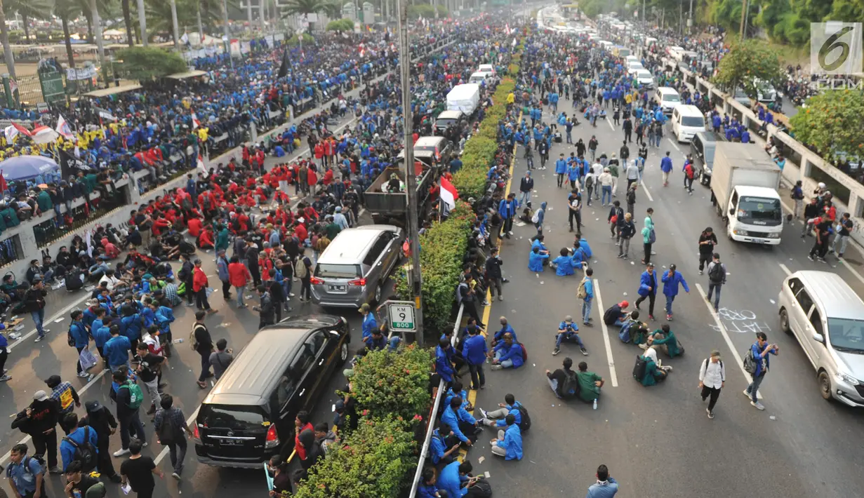Mahasiswa memblokade Tol Dalam Kota saat berdemonstrasi menolak RUU KUHP dan revisi UU KPK di depan Gedung DPR, Jakarta, Selasa (24/9/2019). Demonstrasi mahasiswa membuat arus lalu lintas Tol Dalam Kota lumpuh. (merdeka.com/Arie Basuki)