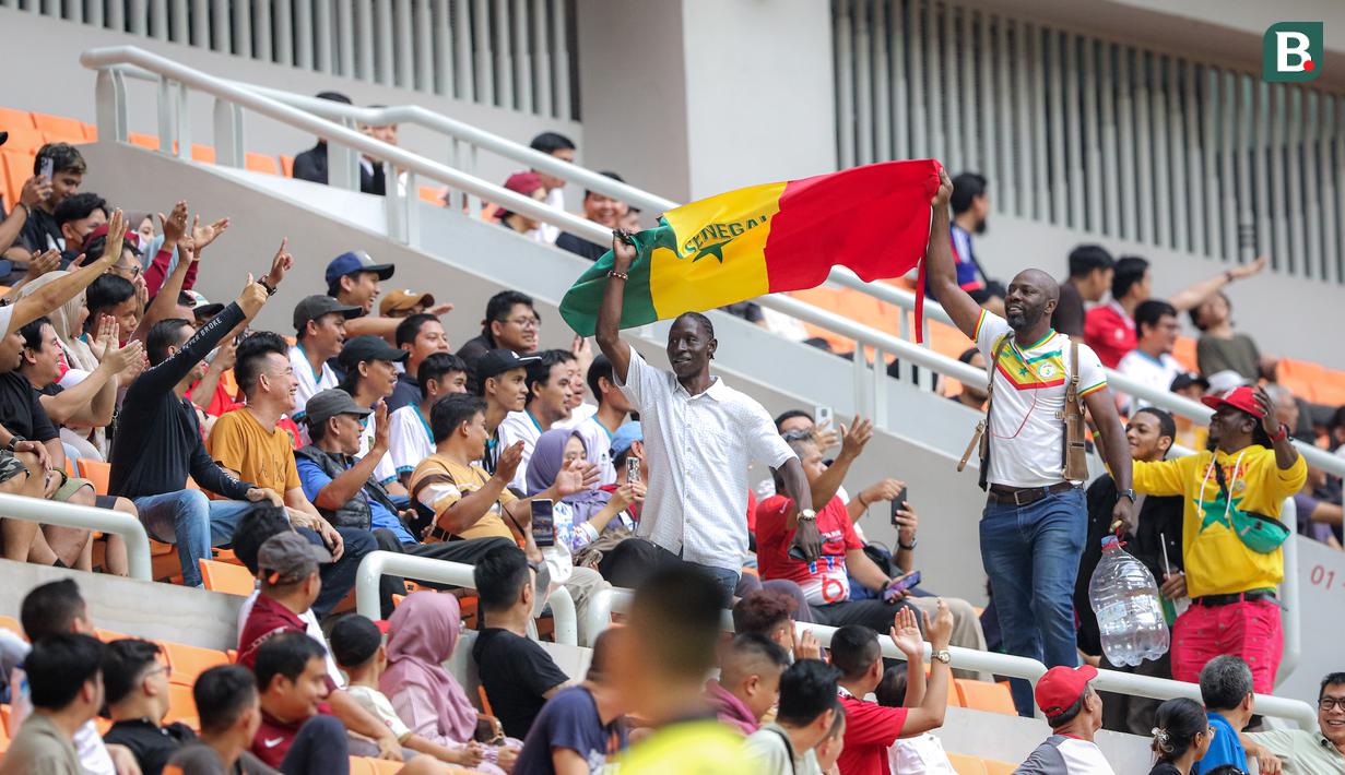 Sejumlah suporter Senegal memasuki tribune dengan membawa bendera dan galon air mineral saat laga 16 Besar Piala Dunia U-17 2023 antara Timnas Prancis U-17 melawan Timnas Senegal U-17 yang berlangsung di Jakarta Internetional Stadium (JIS), Jakarta, Rabu (22/11/2023). (Bola.com/Bagaskara Lazuardi)
