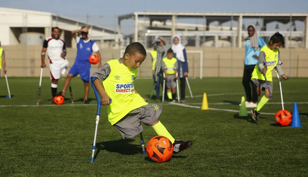 Seorang anak Palestina yang diamputasi menggiring bola saat berlatih di lapangan bermain al-Durra di kota Dier al-Balah, Jalur Gaza tengah (18/10/2019). Tim ini diawasi oleh pelatih Irlandia yang diamputasi Simon Baker.  (AP Photo/Hatem Moussa)