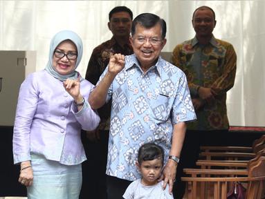 Wakil Presiden Jusuf Kalla (JK) didampingi istri, Mufidah Kalla, menunjukkan jari yang sudah dicelupkan ke tinta setelah melakukan pencoblosan Pilkada DKI 2017 di TPS 03 Kelurahan Pulo, Jakarta Selatan, Rabu (19/4). (Liputan6.com/Herman Zakharia)