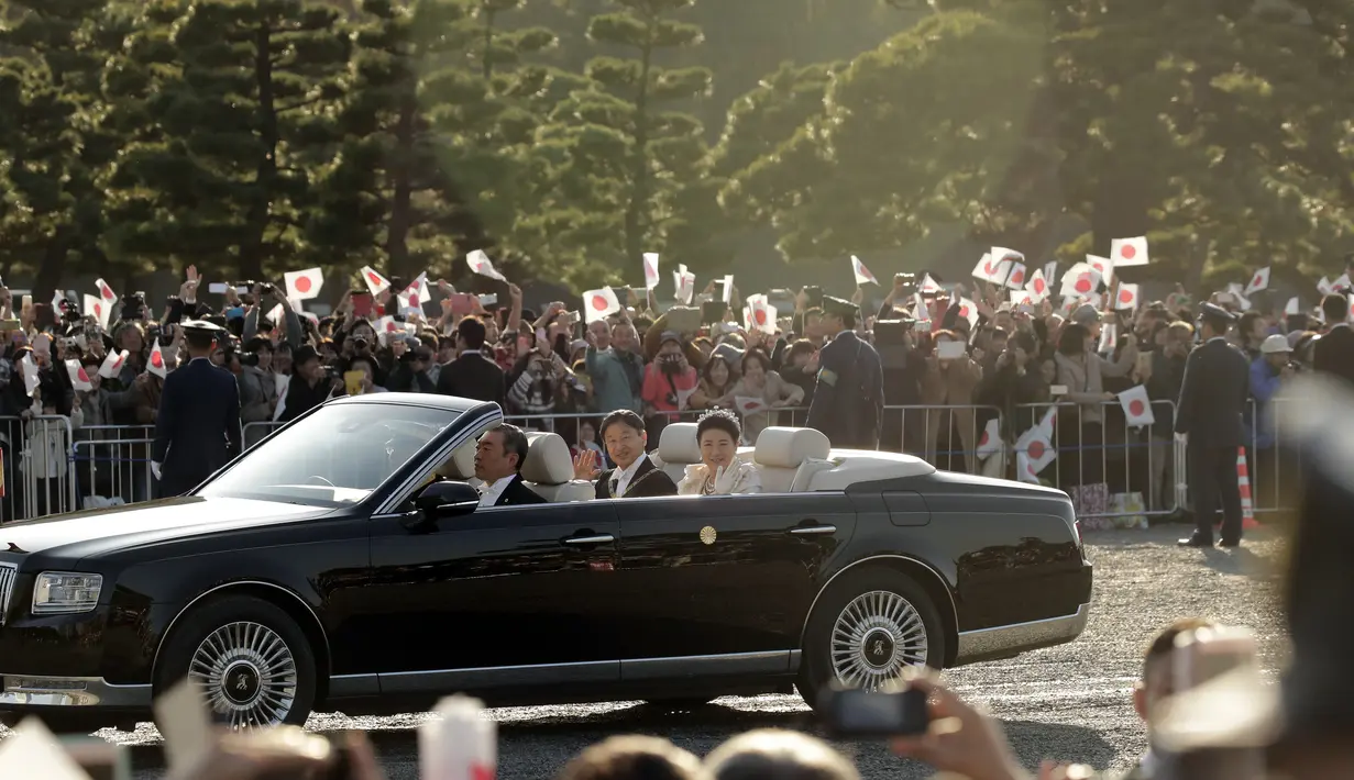 Kaisar Jepang, Naruhito dan Permaisuri Masako menyapa warganya selama parade di Tokyo, Jepang, Minggu (10/11/2019). Parade digelar dalam rangka mengakhiri serangkaian acara penobatan Kaisar Naruhito sejak 1 Mei 2019, atau sehari setelah Akihito turun takhta. (AP Photo/Jae C. Hong)