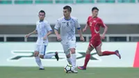 Pemain Uzbekistan, Kenjabaev menggiring bola saat melawan Korea Utara pada laga PSSI Anniversary Cup 2018 di Stadion Pakansari, Bogor, (26/4/2018). Uzbekistan dan Korea Utara bermain imbang 2-2. (Bola.com/Nick Hanoatubun)