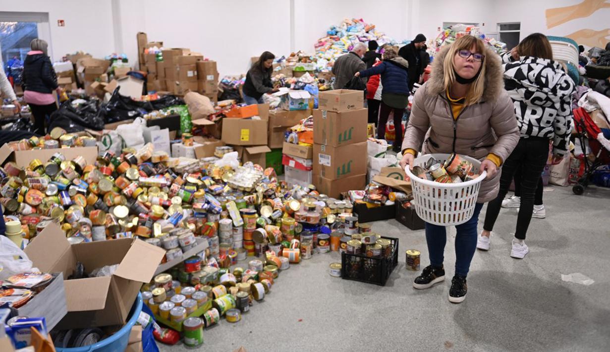 Relawan menyiapkan sumbangan di pusat pengungsi sementara di sekolah dasar setempat di Tiszabecs, Hongaria timur, 28 Februari 2022. Warga Hungaria bergegas ke perbatasan Ukraina untuk membantu pengungsi yang melarikan diri dari invasi Rusia. (Attila KISBENEDEK/AFP)