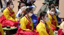 Wanita mengenakan pakaian tradisional Korea Selatan menghadiri upacara untuk menghidupkan kembali Hari Kedewasaan ke-50 di Desa Hanok Namsangol di Seoul, Korea Selatan (16/5/2022). Upacara diadakan untuk pria dan wanita muda yang akan berusia 20 tahun. (AP Photo/Lee Jin-man)