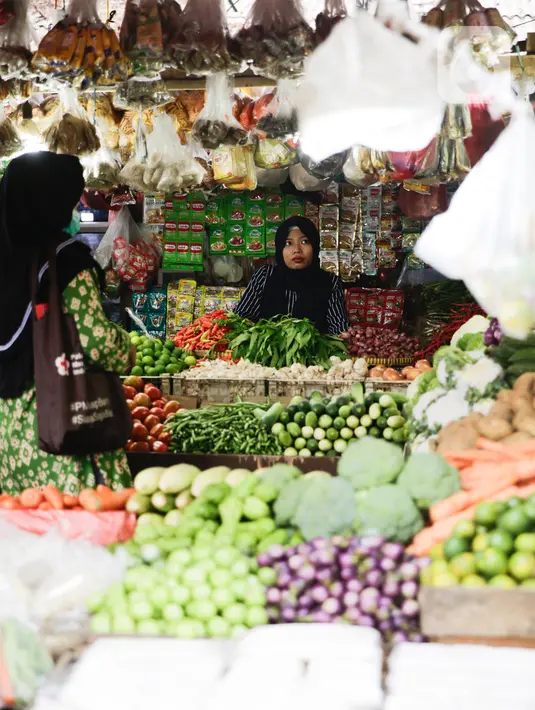 Pedagang melayani pembeli kebutuhan pokok di Pasar Lembang, Tangerang, Selasa (24/8/2021). Berdasarkan survei pemantauan harga yang dilakukan bank sentral pada minggu ketiga Agustus 2021, inflasi diperkirakan sebesar 0,04% secara bulanan atau month on month (mom). (Liputan6.com/Angga Yuniar)