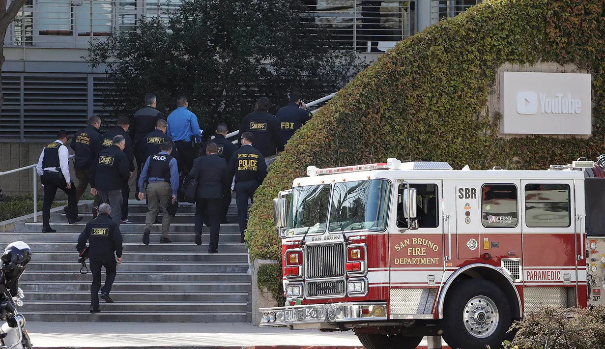 Petugas penegak hukum berjalan masuk ke dalam kantor pusat YouTube usai insiden penembakan di San Bruno, California, Amerika Selatan, Selasa (3/4). Polisi mengatakan tersangka yang identitasnya belum diketahui itu dilengkapi dengan pistol.  (AP/Jeff Chiu)