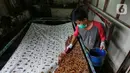 Perajin mewarnai kain batik di rumah produksi batik tanah liek Ayesha Collection di Padang, Sumatera Barat, Kamis (25/11/2021). Batik tanah liek Ayesha yang merupakan UMKM Binaan PT Semen Padang (Semen Indonesia Group) dijual mulai Rp250 ribu hingga jutaan rupiah. (Liputan6.com/Fery Pradolo)