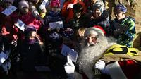 Seorang pria berpakaian Santa Claus berpose bersama anak-anak  saat pembukaan kantor pos Sinterklas di Himmelpfort, Jerman, Kamis (14/11/2019). Anak-anak di seluruh dunia mulai mengirim surat berisi permohonan kepada sinterklas di kantor pos itu. (Tobias SCHWARZ / AFP)