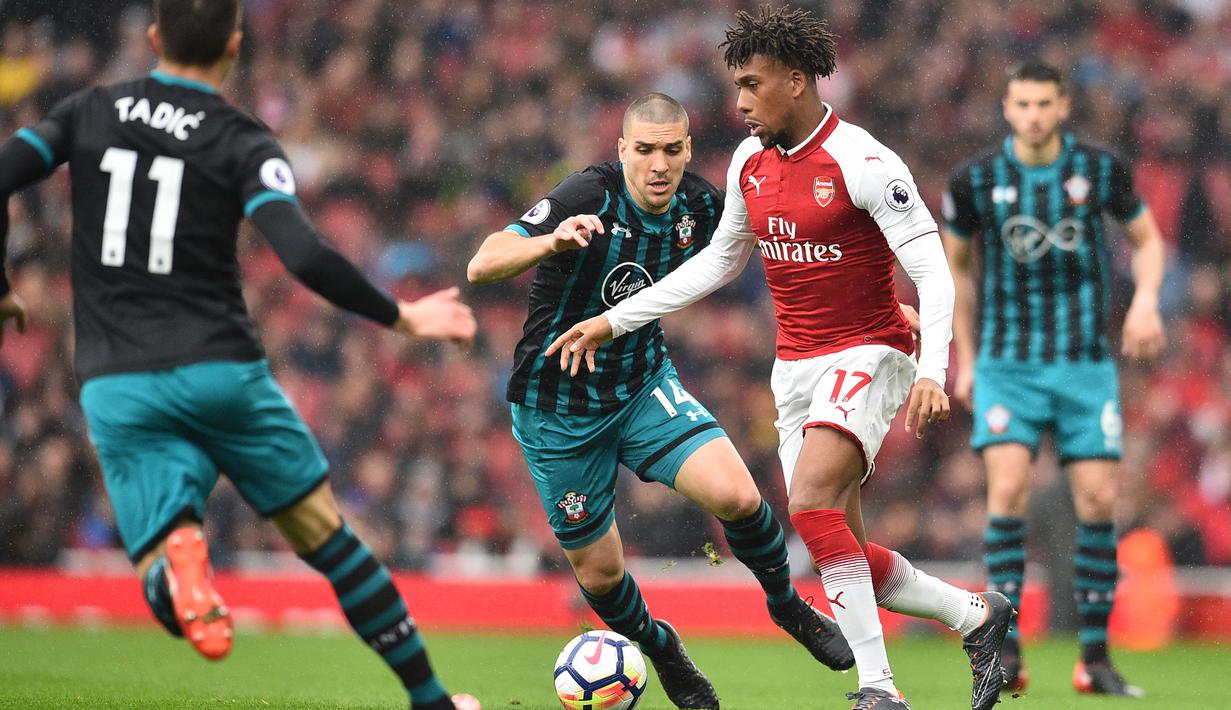 Striker Arsenal, Alex Iwobi, berusaha melewati kepungan pemain Southampton pada laga Premier League di Stadion Emirates, London, Minggu (8/4/2018). Arsenal menang 3-2 atas Southampton. (AFP/Glyn Kirk)