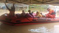 Petugas dari Basarnas mengevakuasi warga akibat ketinggan banjir yang terus meninggi di Kutai Timur. (dok: Basarnas)