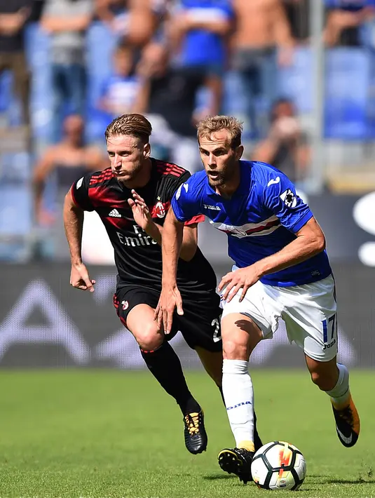 Bek AC Milan, Ignazio Abate berusaha merebut bola pemain Sampdoria, Ivan Strinic saat bertanding pada lanjutan Liga Serie A Italia di Stadion Luigi Ferraris di Genoa (24/9). AC Milan takluk dari Sampdoria dengan skor 2-0. (AFP Photo/Filippo Monteforte)