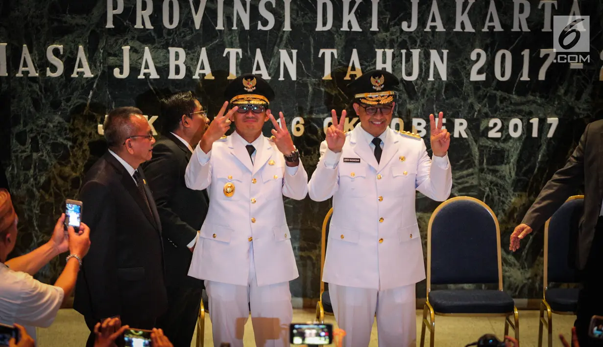 Gubernur dan Wagub DKI Jakarta, Anies Baswedan (kanan) dan Sandiaga Uno (kiri) berfoto bersama usai sertijab di Balai Kota, Jakarta, Senin (16/10). (Liputan6.com/Faizal Fanani)