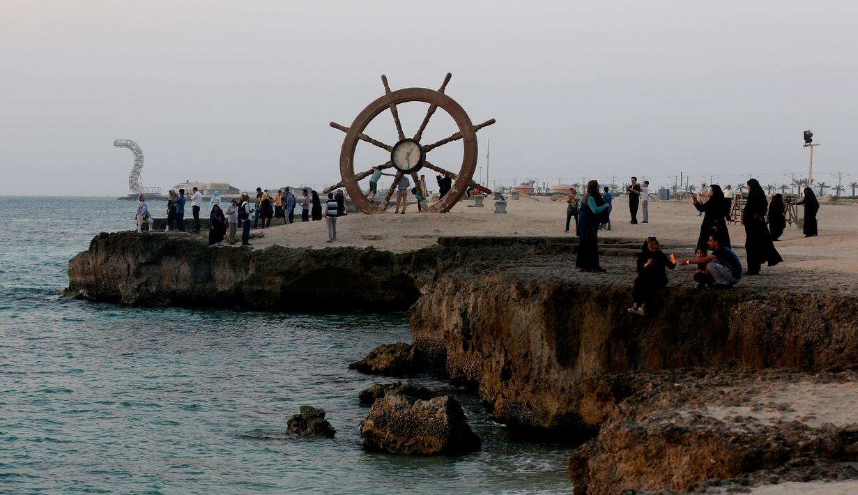 Sejumlah wisatawan bersantai di pinggir laut, Pulau Kish, Iran, 1 November 2016. Pulau Kish merupakan bagian dari Iran yang menyuguhkan pemandangan pantai-pantai indah di sepanjang Teluk Persia. (Atta Kenare/AFP)