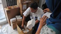 Petugas memeriksa kemasan kardus telepon seluler ilegal di gudang distributor, di ruko kawasan Cempaka Mas, Jakarta, Senin(15/6/2015). Penggeledahan tersebut terkait beberapa laporan dari masyarakat. (Liputan6.com/Herman Zakharia)