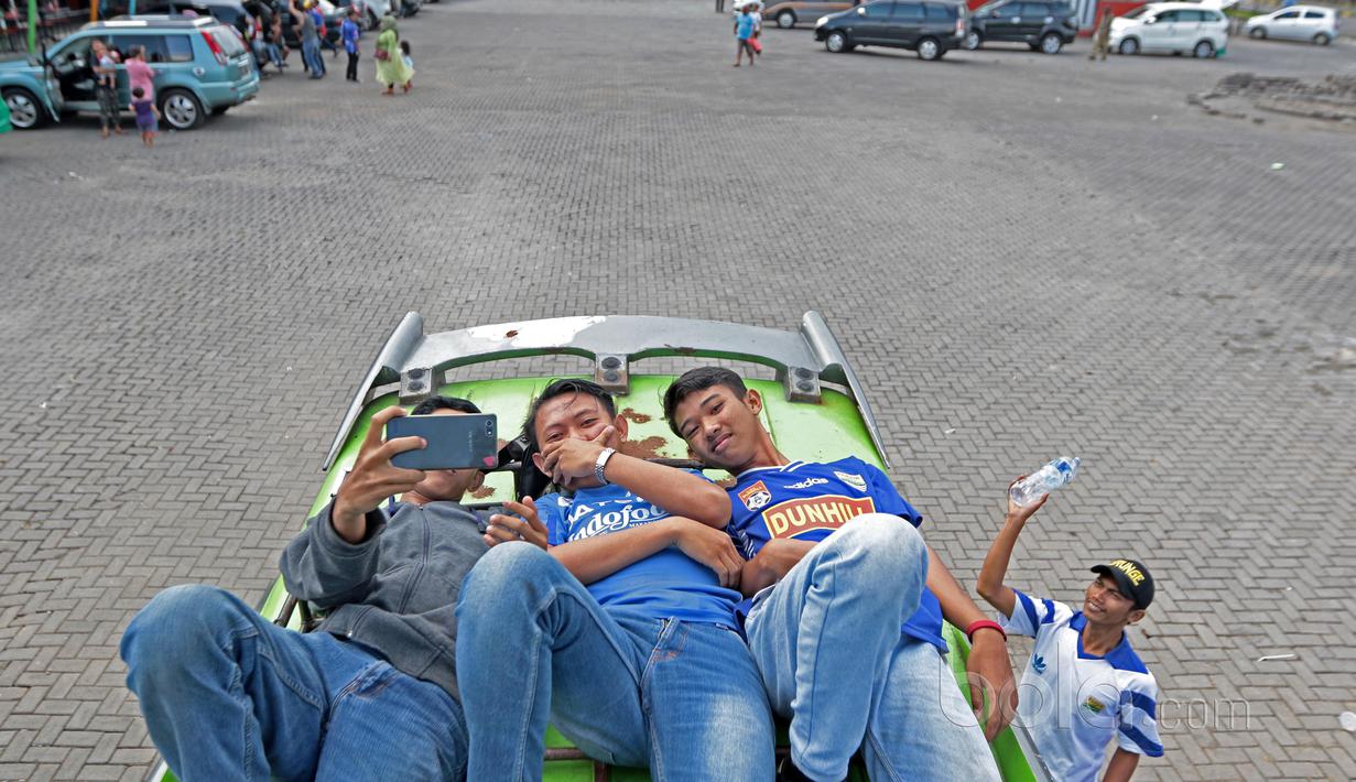 Bobotoh asal Cikampek beristirahat sambil berfoto di Rest Area 147, Bandung, Minggu (7/5/2017).  Bobotoh dengan berbagai jenis kendaraan menuju Stadion GBLA untuk mendukung Persib Bandung melawan Persipura. (Bola.com/Nicklas Hanoatubun)