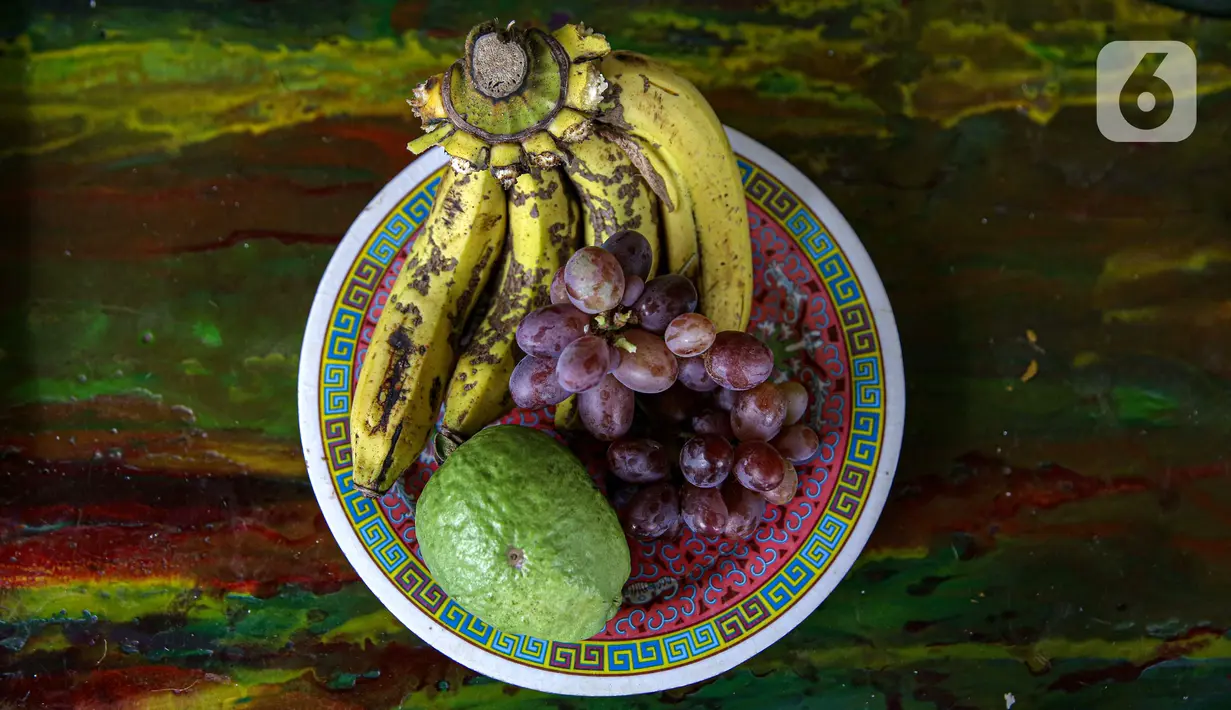 Pisang, anggur, dan jambu hasil panen dari bantaran Kali Ciliwung, Petamburan, Jakarta Pusat, Senin (24/5/2021). Pemanfaatan lahan bantaran Kali Ciliwung untuk bertani bersama dilakukan sebagai upaya memenuhi kebutuhan hidup di tengah keterbatasan lahan. (Liputan6.com/Faizal Fanani)