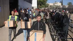 Warga Palestina mengangkat kotak bantuan dari Program Pangan Dunia (WFP) di pusat distribusi di desa Al-Zawayda, di tengah-tengah Jalur Gaza, pada 27 Oktober 2025. (BASHAR TALEB/AFP)