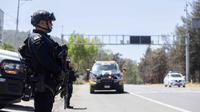 Petugas polisi melakukan pemeriksaan keamanan di Jalan Raya Morelia-Patzcuaro untuk mencegah pembakaran kendaraan dan blokade jalan di negara bagian Michoacan, Meksiko, pada 23 Februari 2026. (Enrique Castro/AFP)