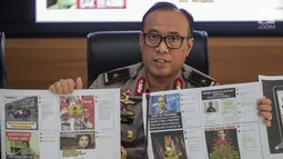 Karopenmas Divisi Humas Polri Brigjen Pol Dedi Prasetyo menunjukkan barang bukti kasus pemberitaan hoax di Jakarta, Senin (1/7/2019). Dalam pengungkapan kasus tersebut kepolisian menangkap pelaku penyebar berita hoax dengan akun media sosial bernama /rif_oposite. (Liputan6.com/Faizal Fanani)