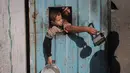 Warga Palestina yang terlantar, anak-anak, dan dewasa, menunggu makanan di sebuah tempat penampungan yang telah dihuni keluarga-keluarga di Nuseirat, pusat Jalur Gaza, pada 23 November 2025. Badan kemanusiaan Perserikatan Bangsa Bangsa (PBB) untuk Koordinasi Urusan Kemanusiaan (OCHA) mengatakan pada Sabtu 22 November 2025 bahwa peningkatan bantuan untuk Gaza masih terhambat. (EYAD BABA/AFP)