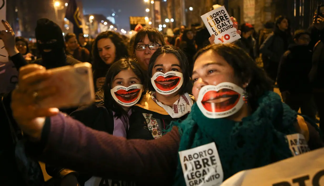 Para gadis berselfie saat ikut aksi mendukung sebuah undang-undang melegalkan aborsi di Santiago, Chile (25/7).Tiga situasi tersebut ketika kehidupan ibu berada dalam bahaya, ketika janin tidak layak, dan dalam kasus pemerkosaan. (AP Photo/Esteban Felix)