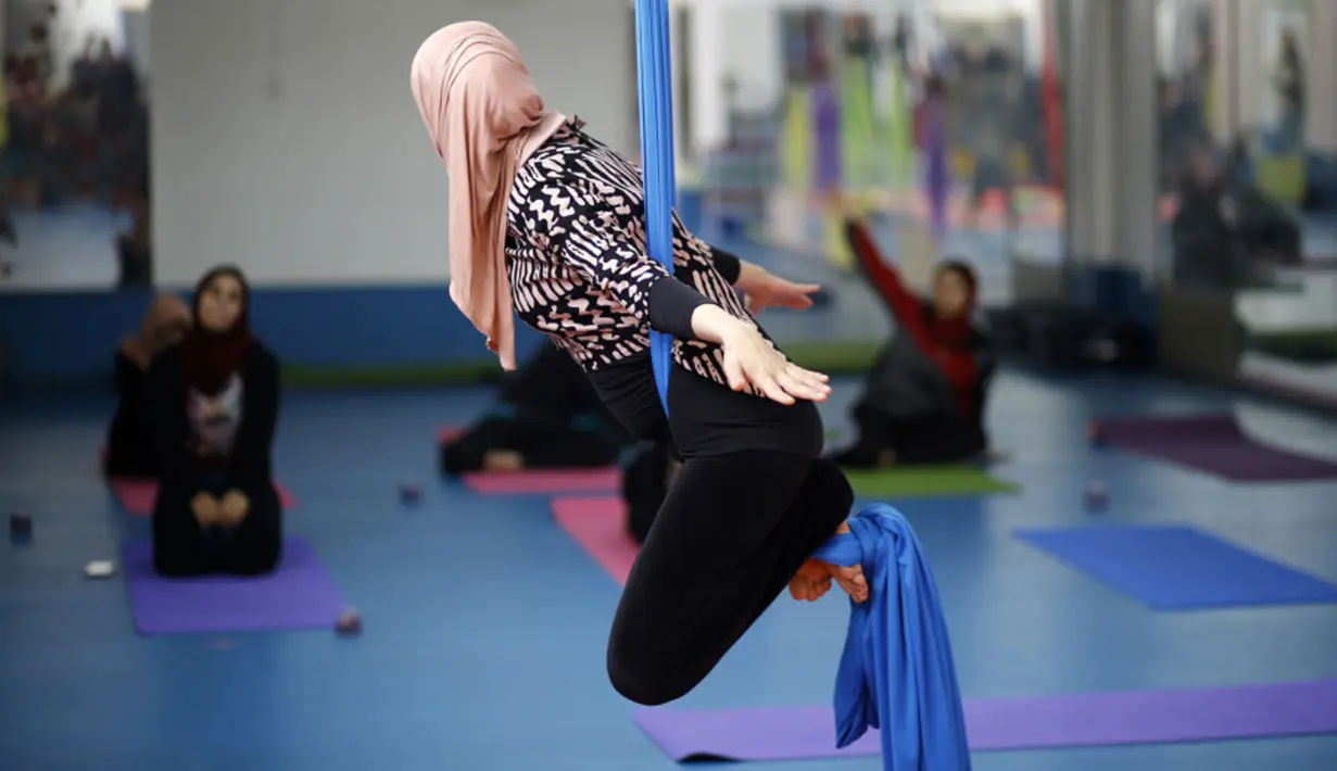Seorang wanita Palestina melakukan sesi latihan yoga di pusat pelatihan yoga wanita pertama di kota Gaza, 28 Maret 2018. Kelas yoga dengan menggunakan pusat kebugaran darurat ini bertujuan  melatih 32 perempuan sebagai pelatih Yoga. (MOHAMMED ABED/AFP)
