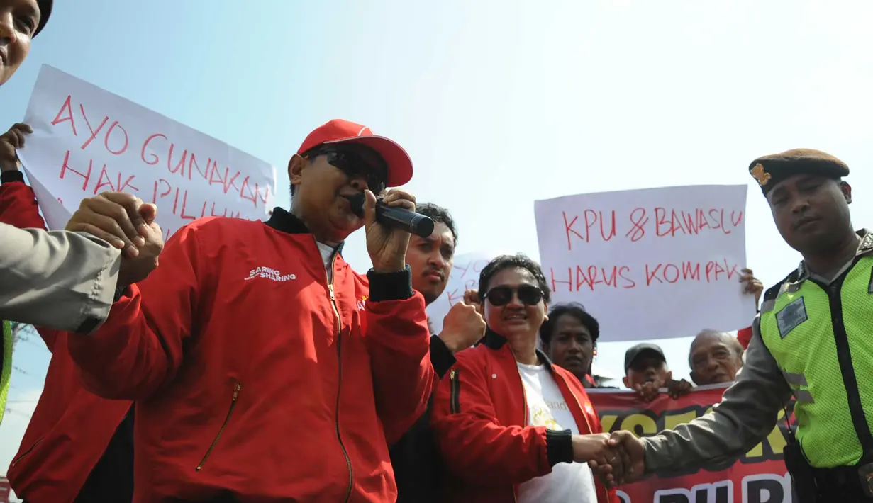 Sejumlah jurnalis bersalaman dengan petugas kepolisian saat melakukan aksi unjuk rasa di Jalan Pahlawan Semarang, Jumat ( 5/4). Aksi jurnalis Semarang tersebut untuk mengajak masyarakat perangi hoaks saat kampanye dan masa tenang Pemilu 2019. (Liputan6.com/Gholib)