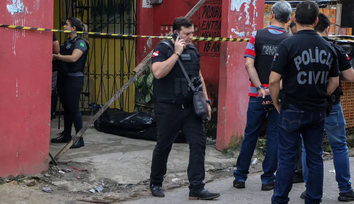 Sejumlah petugas mengecek bar usai penembakan massal di kota Belm, negara bagian utara Par, Brazil (19/5/2019). Sebanyak 11 orang dilaporkan tewas dalam serangan yang dilakukan 7 pria bersenjata tersebut. (Claudio Pinheiro/Agencia Panamazonica/AFP)