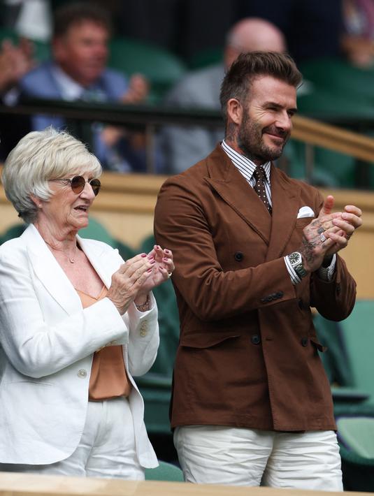 Mantan pesepakbola David Beckham dan ibunya Sandra Georgina West bertepuk tangan dari Royal Box di Centre Court selama pertandingan tenis perempat final tunggal putri antara Simona Halep dari Rumania dan pemain AS Amanda Anisimova pada hari kesepuluh Kejuaraan Wimbledon 2022 di The Klub Tenis All England di Wimbledon, London (6/7/2022). (AFP/Adrian Dennis)