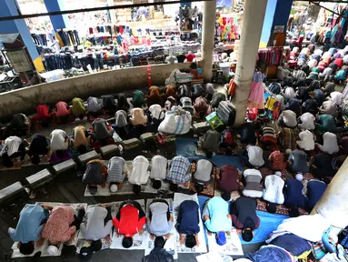 Umat muslim melakukan salat Jumat diantara kios-kios Pedagang Tanah Abang, Jakarta, Jumat (9/6). Dikarenakan membeludaknya jamaah yang ingin beribadah mereka terpaksa melakukan salat di antara kios-kios pasar. (Liputan6.com/Johan Tallo)
