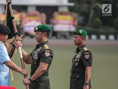 Panglima TNI Marsekal Hadi Tjahjanto memberikan panji TNI AD kepada pejabat baru Kepala Staf TNI Angkatan Darat (KSAD) Jenderal TNI Andika Perkasa saat upacara serah terima jabatan di Mabes TNI AD, Jakarta, Kamis (29/11). (Liputan6.com/Faizal Fanani)