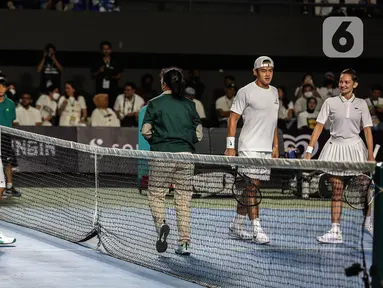 Pasangan ganda campuran Gading Marten/Wulan Guritno (kiri) melawan Dion Wiyoko/Enzy Storia (kanan) pada pertandingan pembuka Tiba Tiba Tenis di Tennis Indoor Senayan, Jakarta, Sabtu (12/11/2022). Pasangan Dion Wiyoko/Enzy Storia berhasil mengalahkan Gading Marten/Wulan Guritno dua set langsung dengan skor meyakinkan, 6-2 dan 6-3. (Liputan6.com/Johan Tallo)