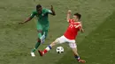 Aksi pemain Arab Saudi, Omar Othman (kiri) melepaskan tembaan saat diadang pemain Rusia, Alexander Golovin pada laga grup A Piala Dunia 2018 di Luzhniki stadium, Moskow, Rusia, (14/6/2018). Rusia menang 5-0. (AP/Darko Bandic)