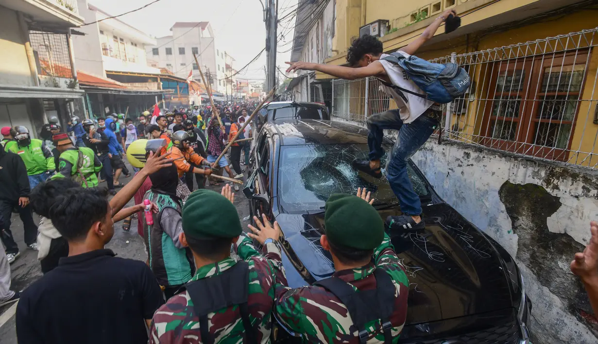 Massa merusak dan membakar kendaraan roda empat yang terparkir di depan Mako Korps Brimob Polda Metro Jaya di kawasan Kwitang, Jakarta Pusat, Jumat (29/8/2025). (merdeka.com/Arie Basuki)