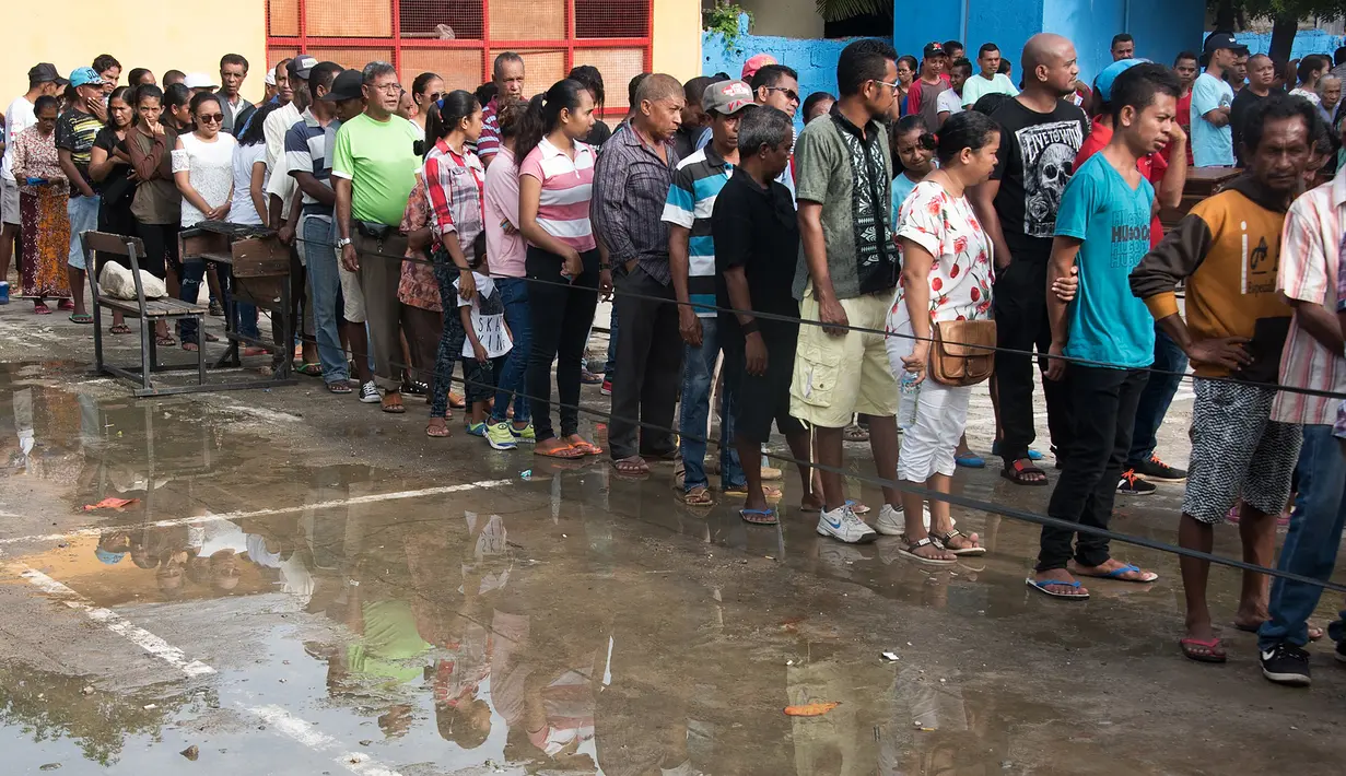 Antrean warga Timor Leste untuk menggunakan hak pilih mereka di tempat pemungutan suara (TPS) di Dili, Senin (20/3). Sedikitnya 1,2 juta warga akan memilih presiden baru, menggantikan Presiden Taur Matan Ruak. (Valentino DARIEL SOUSA/AFP)