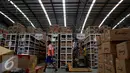 Pekerja melintas di antara rak barang di gudang milik Lazada Online Shop, Jakarta, Jumat (9/12). Hari Belanja Online Nasional yang jatuh pada 12 Desember 2016 dimanfaatkan situs belanja online untuk menarik pembeli. (Liputan6.com/Johan Tallo)