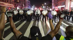 Para pengunjuk rasa berlutut di Flatbush Avenue di depan petugas kepolisian Kota New York selama unjuk rasa untuk George Floyd di wilayah Brooklyn di New York, AS (4/6/2020). (AP Photo/Frank Franklin II)