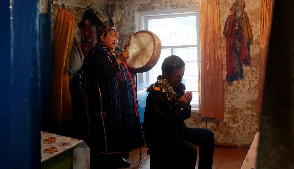 Seorang dukun menabuh alat musik saat mengusir roh jahat di kediaman pelanggannya di Kota Kyzyl, Tuva, Siberia, Rusia, (3 /11). (REUTERS/Ilya Naymushin)