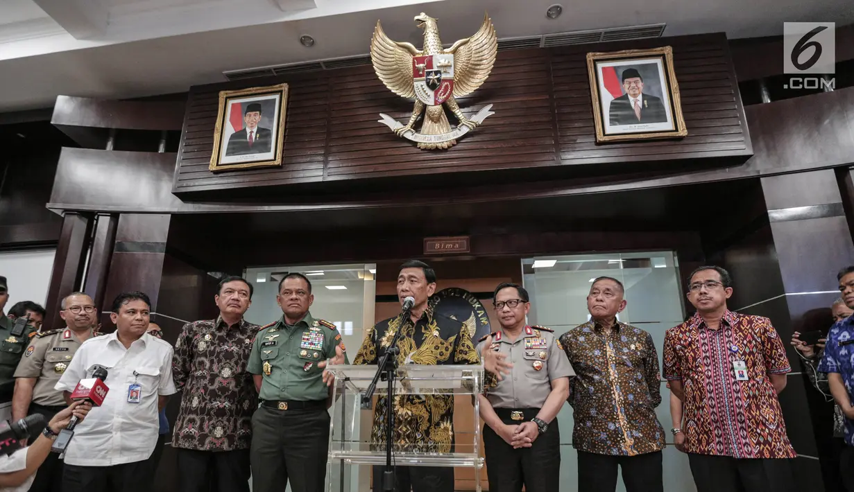Suasana saat Menko Polhukam Wiranto (tengah) memberi keterangan di Kemenkopolhukam, Jakarta, Jumat (6/10). Dalam keterangannya, Wiranto menyebutkan ada banyak regulasi yang mengatur mengenai pengadaan senjata api. (Liputan6.com/Faizal Fanani)