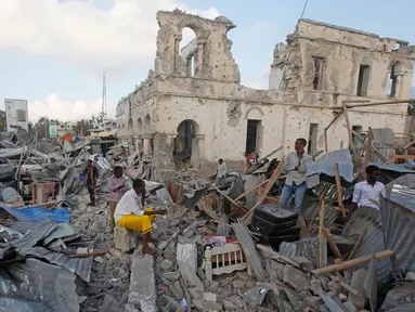 Warga berkumpul di bangunan yang hancur menyusul serangan bom mobil kembar di Ibu Kota Mogadishu, Somalia, Sabtu (24/2). Dua ledakan bom mobil mengguncang Mogadishu pada Jumat, 23 Februari 2018 malam. (AP Photo/Farah Abdi Warsameh)