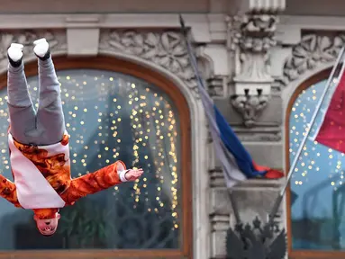 Seorang pemain akrobat melompat saat pertunjukan jalanan di Moskow, Rusia (2/1). Sejumlah seniman jalanan dan warga turun ke jalan untuk merayakan Natal Orthodox yang jatuh pada tanggal 7 Januari. (AFP Photo/Yuri Kadobnov)