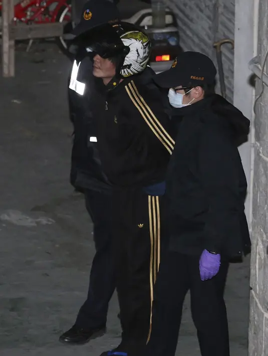Polisi menggiring pelaku pemenggal bocah perempuan (tengah) ke Pusat Penahanan Taipei, Taiwan, Selasa (29/3). Pria itu menyeret gadis berusia tiga tahun yang menaiki sepeda dan memenggalnya di depan ibu korban. (REUTERS/Tony HuangTAIWAN OUT)