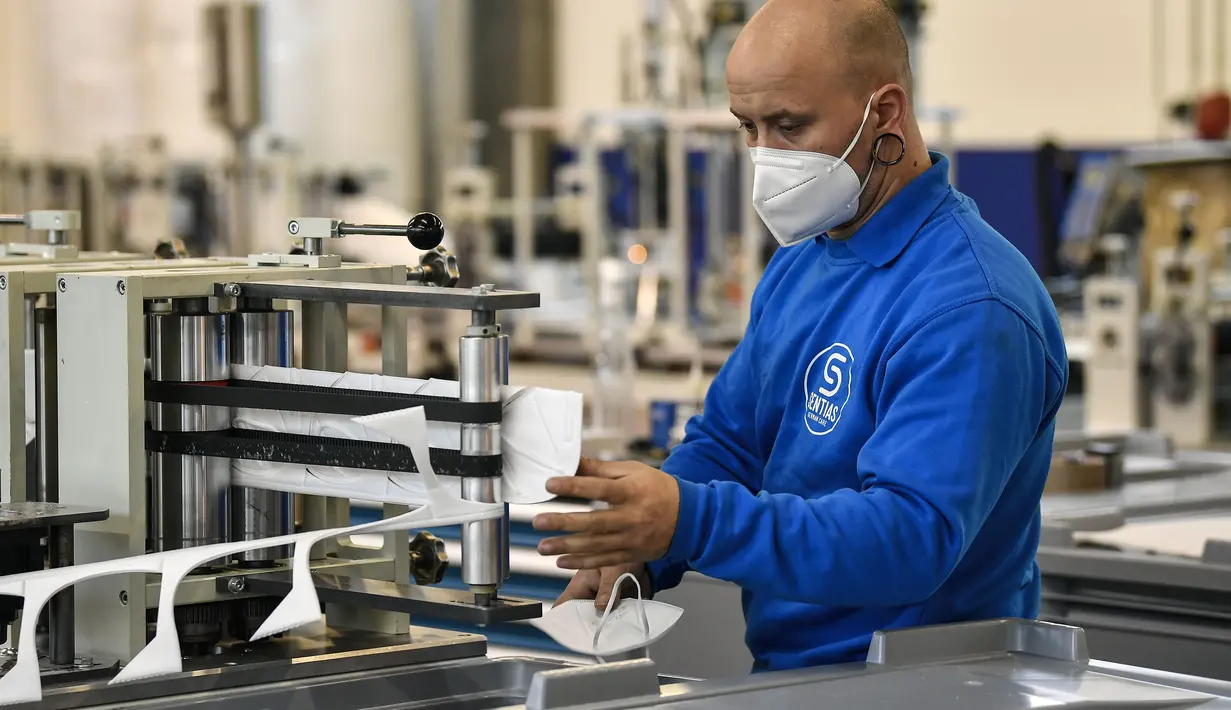 Seorang karyawan mengontrol produksi masker FFP2 untuk melawan pandemi COVID-19 di produsen masker Sentias di Wuppertal, Jerman, Kamis (28/1/2021). Jerman mewajibkan masker medis jenis KN95 atau FFP2 digunakan saat bepergian dengan transportasi umum atau perbelanjaan. (AP Photo/Martin Meissner)
