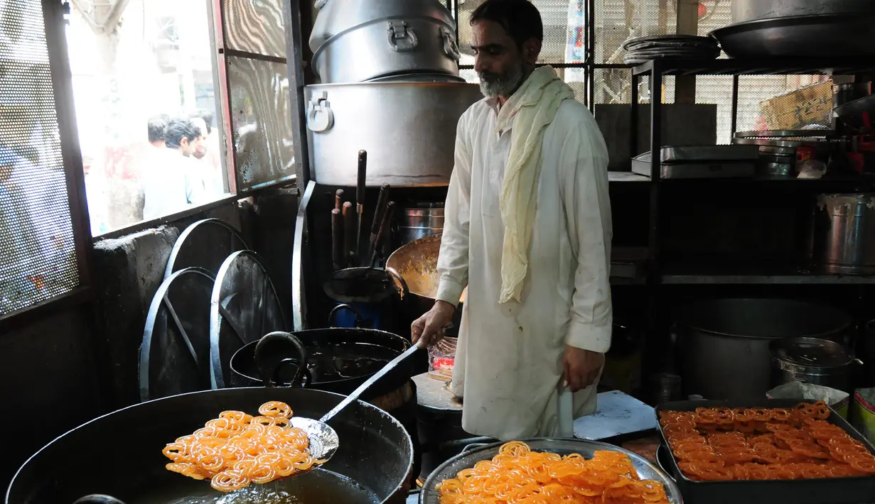 Seorang pria membuat penganan manis tradisional di hari raya Idul Fitri di Peshawar, Pakistan barat laut, pada 25 Mei 2020. Warga Pakistan memiliki tradisi memakan penganan manis saat merayakan Idul Fitri, yang menandai akhir bulan puasa Ramadan. (Xinhua/Saeed Ahmad)