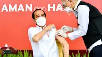 Presiden Joko Widodo atau Jokowi (kiri) disuntik vaksin COVID-19 di Istana Merdeka, Jakarta, Rabu (13/1/2021). Vaksinator menyuntikkan vaksin di lengan kiri Presiden Jokowi sekitar pukul 09.42 WIB. (Biro Pers Sekretariat Presiden/Laily Rachev)