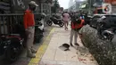 Warga pelanggar PSBB dihukum menyapu saat terjaring razia masker di Jalan Tanjung Duren Raya, Jakarta, Jumat (11/9/2020). Petugas Satpol PP gencar melakukan razia masker menyusul kasus COVID-19 di DKI Jakarta yang terus meningkat. (merdeka.com/Imam Buhori)