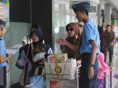 Petugas memeriksa kecocokan tiket calon penumpang pesawat di Bandara Halim Perdanakusuma Jakarta, Senin (4/7). H-2 jelang Idul Fitri 1437 H, ribuan calon penumpang diberangkatkan dari Bandara Halim Perdanakusuma. (Liputan6.com/Helmi Fithriansyah)