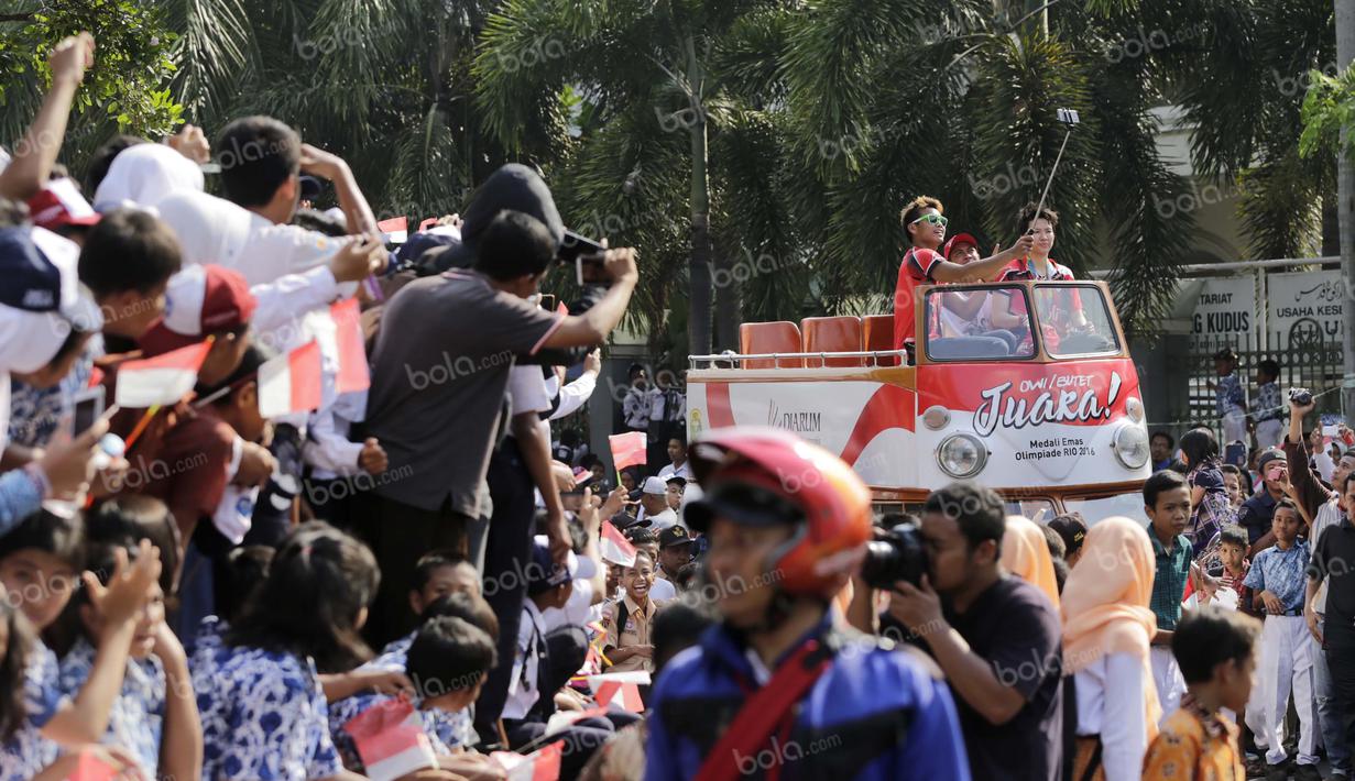 Peraih emas bulutangkis Olimpiade Rio 2016, Tontowi Ahmad dan Liliyana Natsir, ditengah ribuan warga Kudus saat kirab melewati alun-alun kota Kudus, Kamis (1/9/2016). (Bola.com/Arief Bagus)