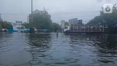 Seorang pria berdiri di antara genangan banjir yang mengepung Kota Semarang, Jawa Tengah, Sabtu (6/2/2021). Hujan deras sejak Jumat malam hingga Sabtu pagi, 6 Februari 2021 membuat sejumlah kawasan di Kota Semarang dikepung banjir. (Liputan6.com/Gholib)